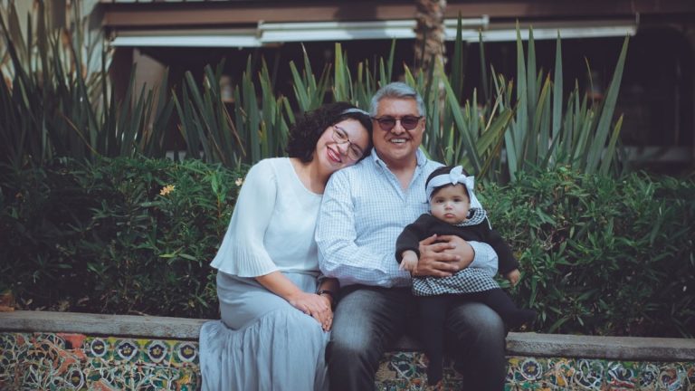 a man and woman sitting on a bench with a baby